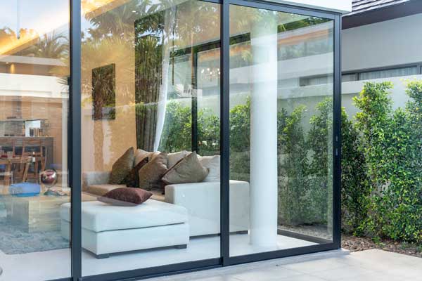 A modern sliding glass door framing a backyard view