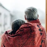 Elderly couple looking out window thinking about aging in place | Lifetime Windows & Doors