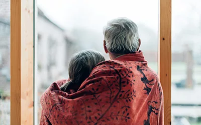 Elderly couple looking out window thinking about aging in place | Lifetime Windows & Doors
